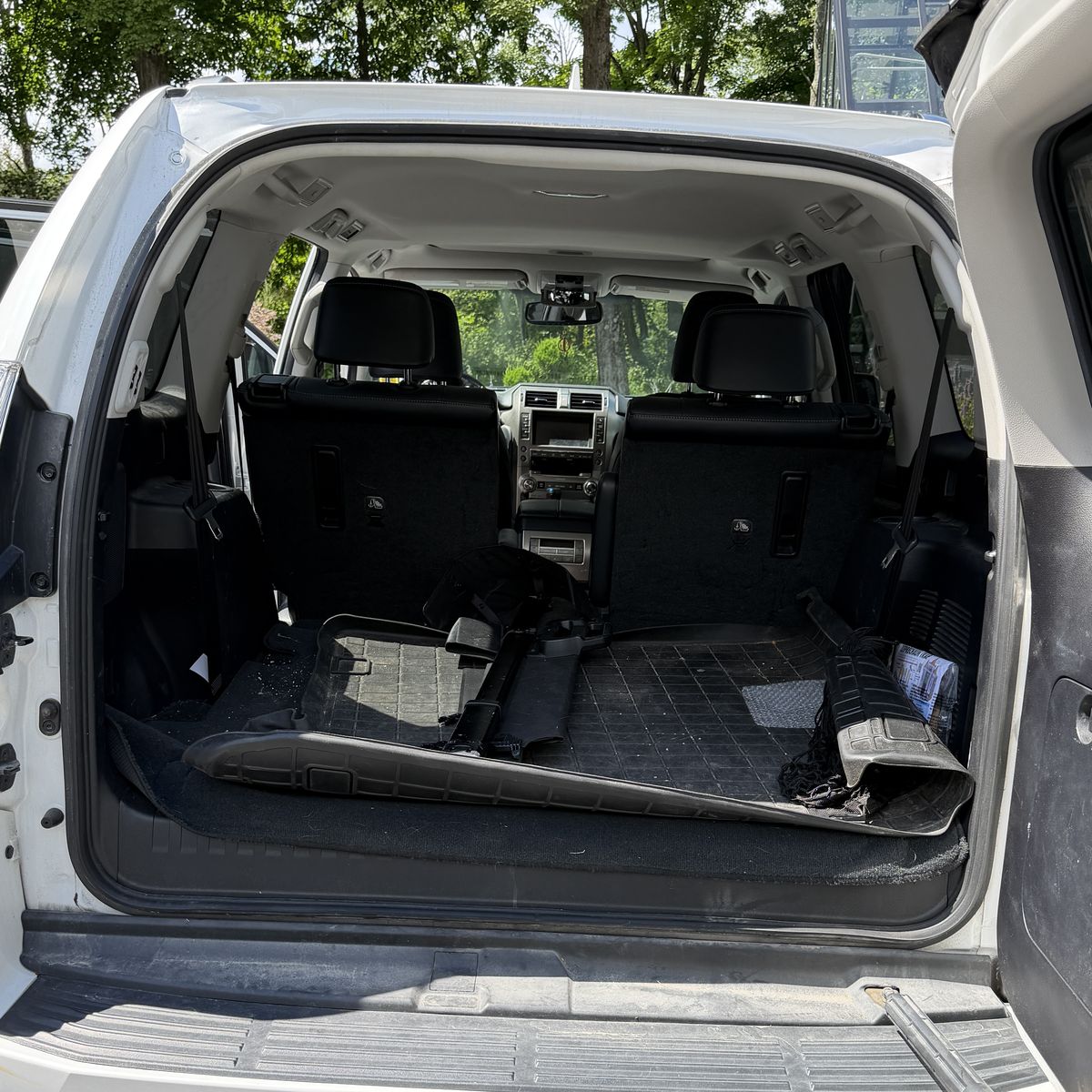 SUV cargo area before cleaning, carpet covered in dirt and loose debris